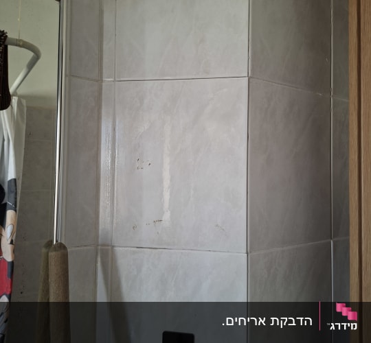 אריחי קרמיקה על קיר חדר אמבטיה